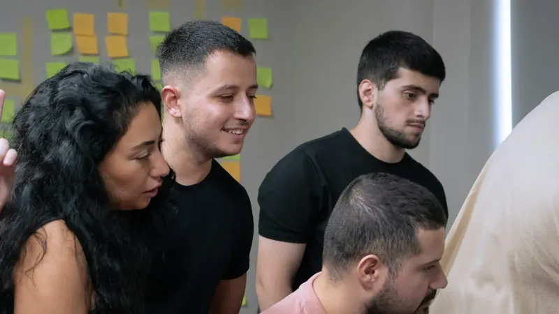 Uma equipa analisa com atenção notas adesivas com ideias numa parede.
