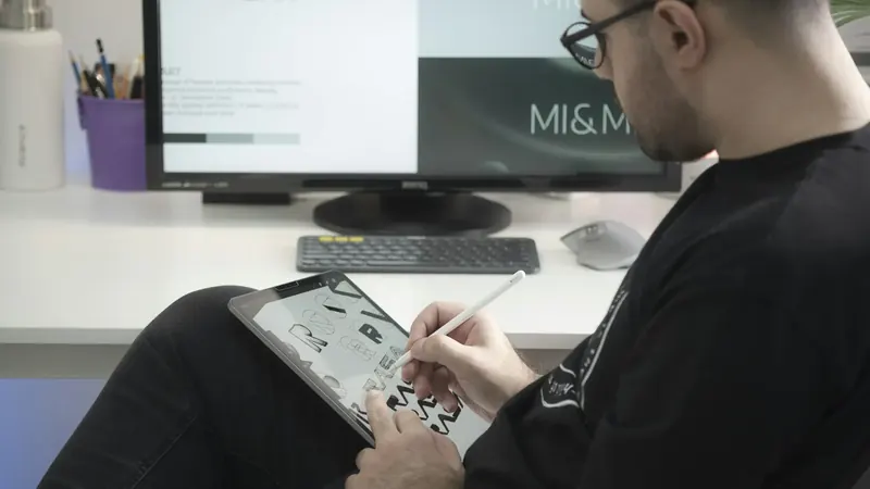 Uma designer de óculos desenha com uma caneta digital num tablet.